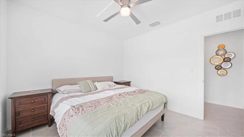 Bedroom with a ceiling fan and light tile patterned flooring