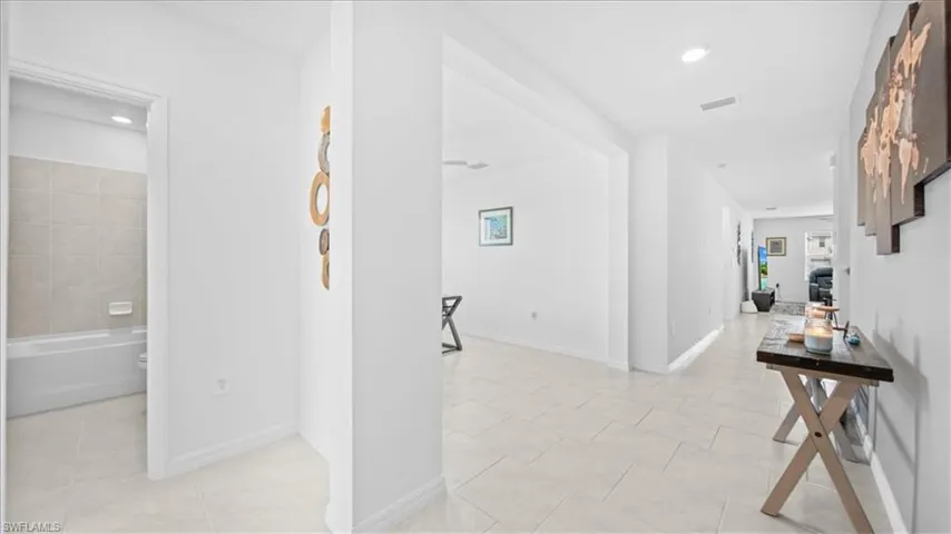 Hall with recessed lighting and light tile patterned flooring