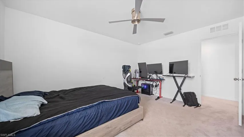 Carpeted bedroom featuring ceiling fan