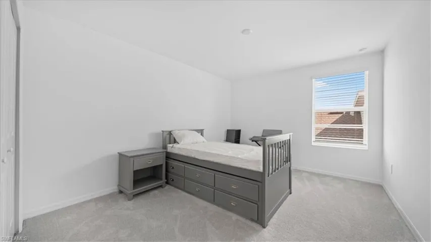 Bedroom featuring light carpet