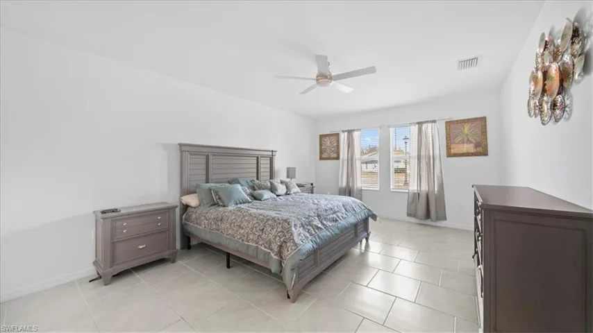 Bedroom with ceiling fan and light tile patterned flooring