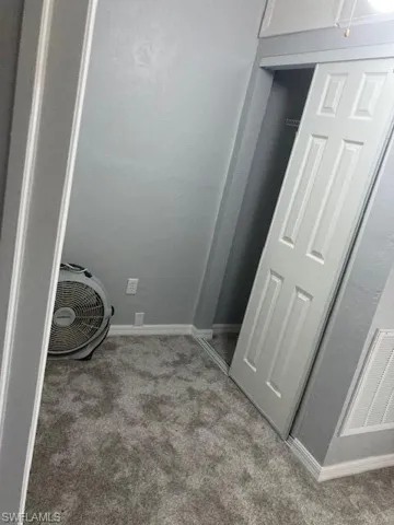 Laundry room featuring light colored carpet