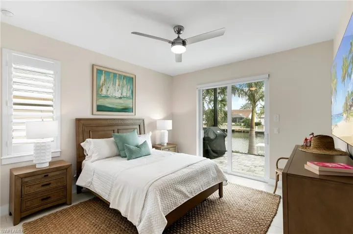 Tiled bedroom featuring ceiling fan and access to exterior