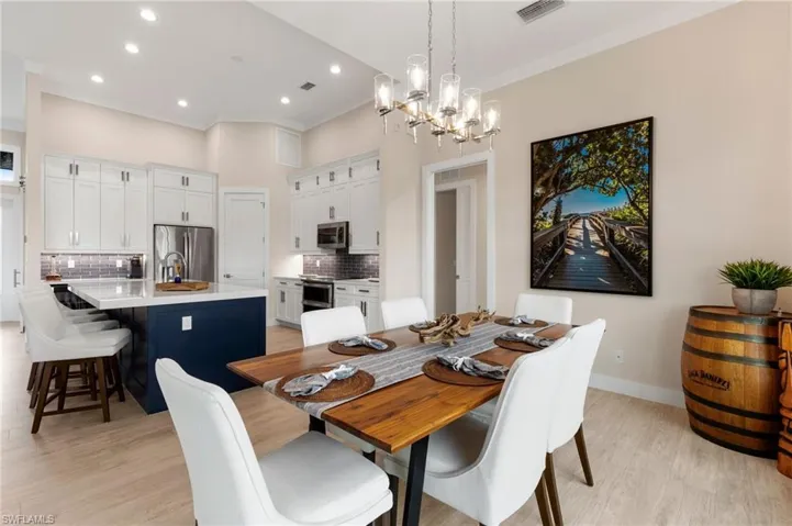 Dining space featuring sink, crown molding, light hardwood / wood-style floors, and an inviting chandelier