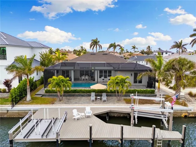 View of dock featuring screen enclosure, a patio area, and a water view
