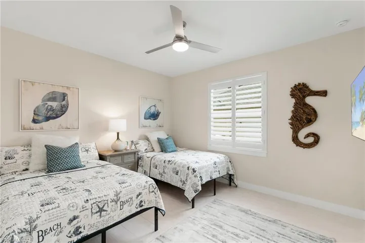 Tiled bedroom featuring ceiling fan