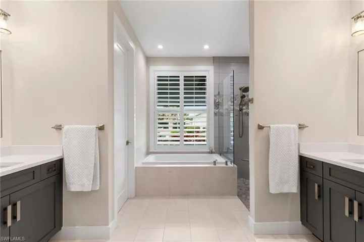 Bathroom with plus walk in shower, tile patterned floors, and vanity