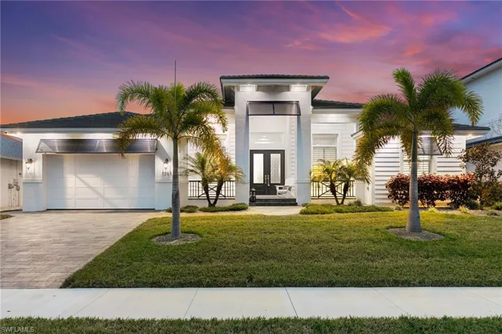 View of front of home featuring a garage and a lawn