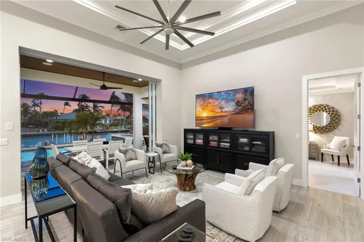 Living room featuring light hardwood / wood-style floors, crown molding, and ceiling fan