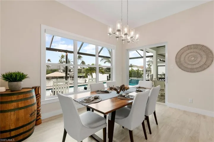 Dining space featuring a chandelier, light hardwood / wood-style floors, and a water view