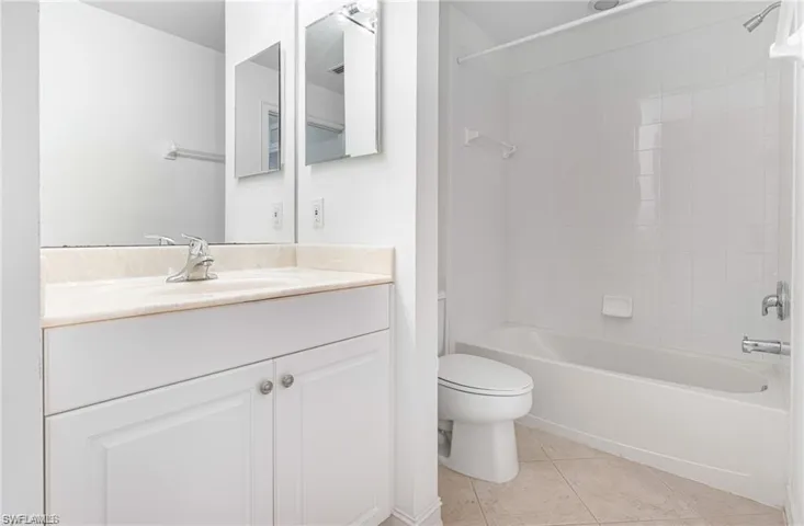 Guest Bathroom featuring Vanity with a Shower/Tub Combo and Tile Patterned Flooring.