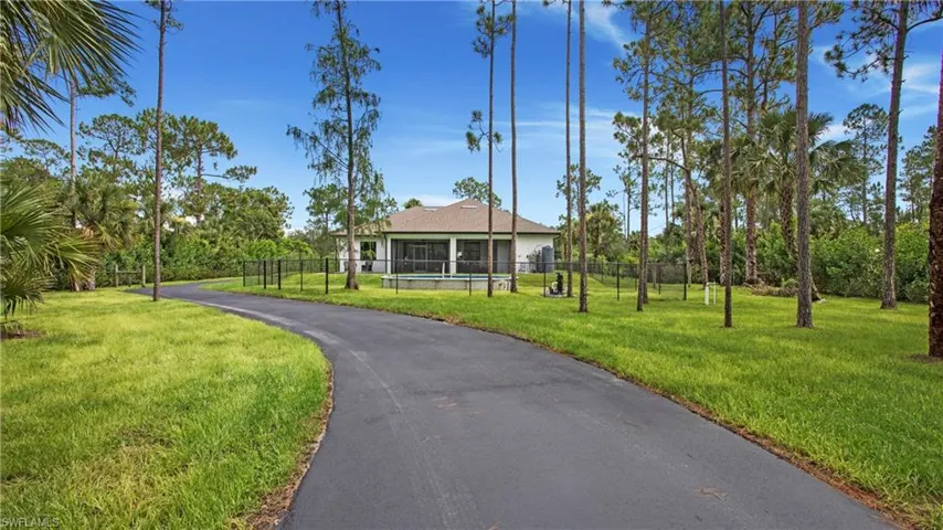 View of front of home with driveway and a sunroom