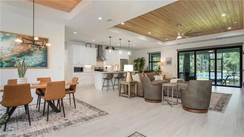 Dining area with a raised ceiling, wood ceiling, a ceiling fan, recessed lighting, and light wood-style flooring