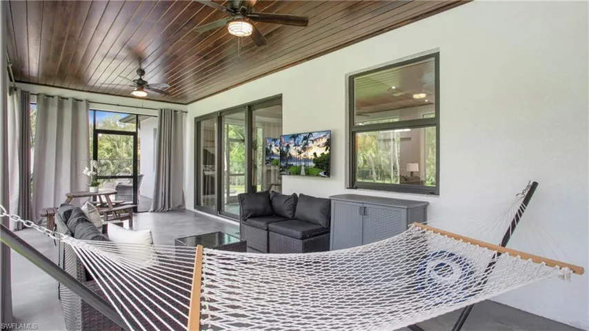 Sunroom / solarium featuring a ceiling fan, outdoor lounge area, and wooden ceiling