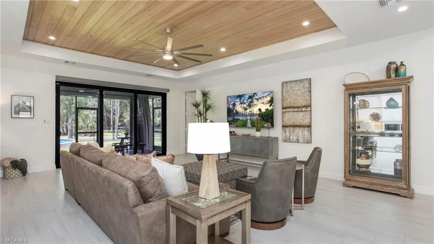 Living area featuring a raised ceiling, wooden ceiling, a ceiling fan, recessed lighting, and light wood finished floors