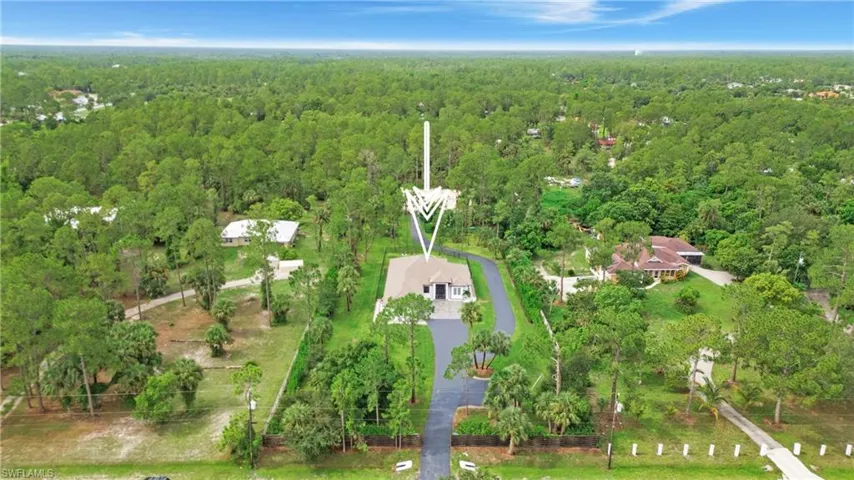 Aerial view of property and surrounding area featuring a forest
