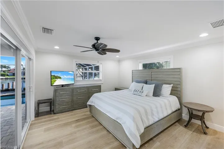 Bedroom featuring access to outside, crown molding, light wood-style flooring, a ceiling fan, and recessed lighting