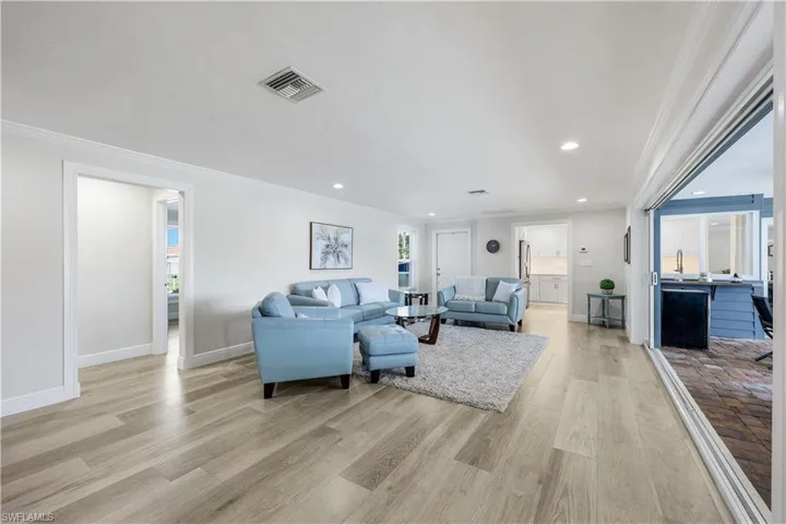 Living area with crown molding, light wood finished floors, and recessed lighting
