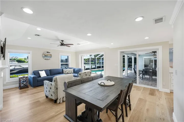 Dining space with crown molding, light wood-style floors, ceiling fan, recessed lighting, and a sunroom