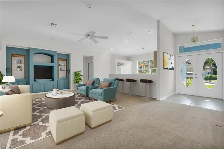 Living room featuring ceiling fan, lofted ceiling, french doors, and light carpet
