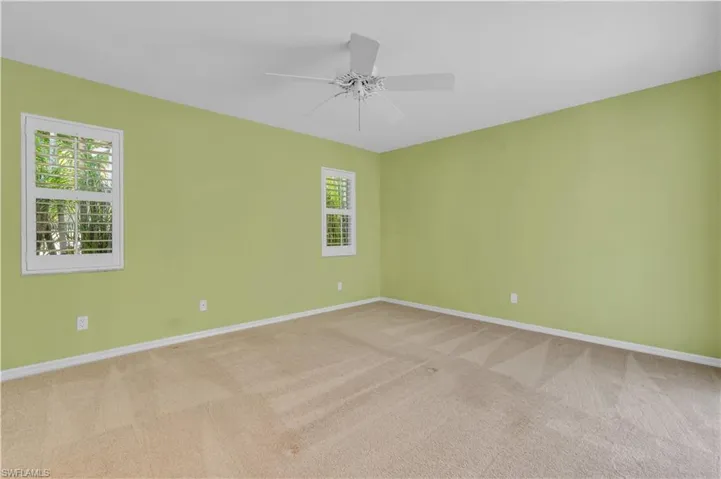 Carpeted spare room featuring ceiling fan