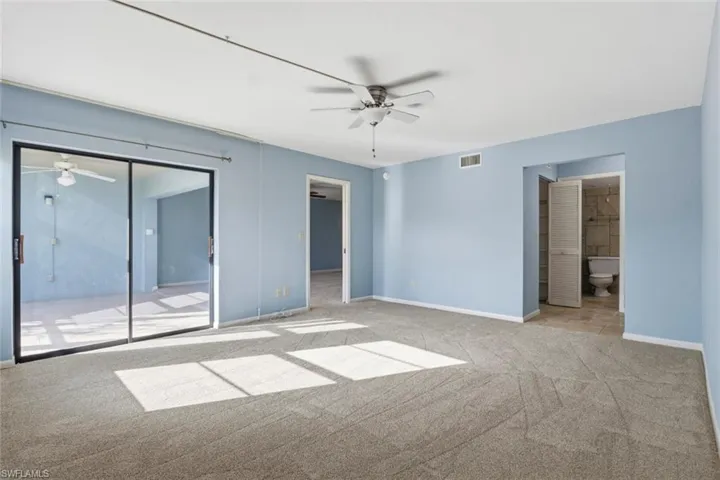 Bedroom featuring a spacious closet, new carpet, lots of natural light. and ensuite bathroom