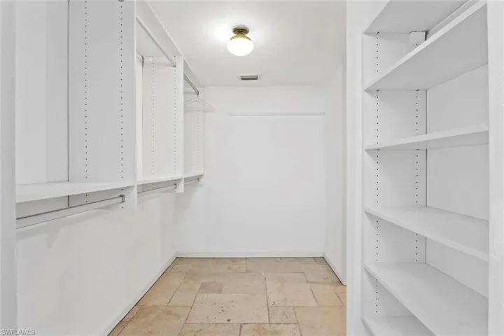 Walk in closet with stone tile flooring