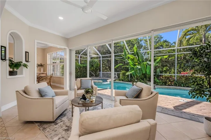 Conversation area within the sun room. Beyond is the updated pool that has been resurfaced and has new tile surrounds.