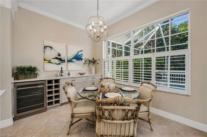 Breakfast area with built-in and drink refrigerator.  Large windows bring the outdoor space in.