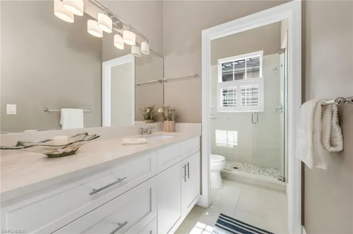 Third bedroom en-suite has a serene bathroom, with seamless glass shower enclosure.