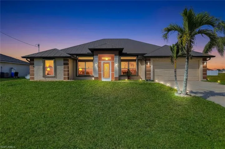 View of front of house featuring a front lawn, concrete driveway, an attached garage, and stucco siding