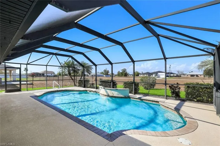 Swimming pool featuring a sunroom, a patio, glass enclosure, and a residential view