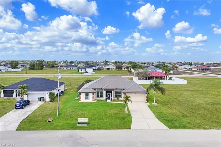 View of front of home featuring a residential view, concrete driveway, an attached garage, and a front lawn