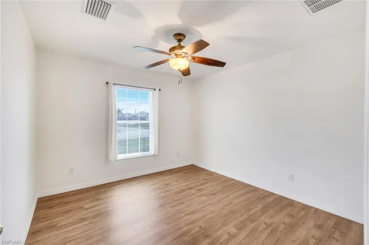 Empty room featuring light wood finished floors and ceiling fan