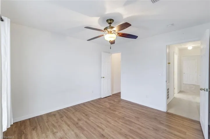 Unfurnished bedroom with ceiling fan and light wood-type flooring