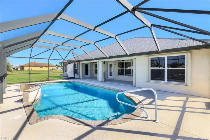 Swimming pool with a patio, a sunroom, a lanai, and a lawn