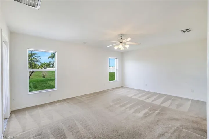 Spare room featuring light carpet and ceiling fan