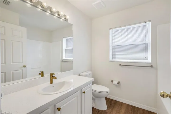 Bathroom featuring vanity and dark wood-style flooring