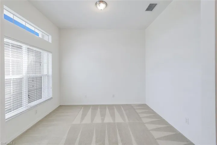 Unfurnished room featuring light colored carpet and baseboards