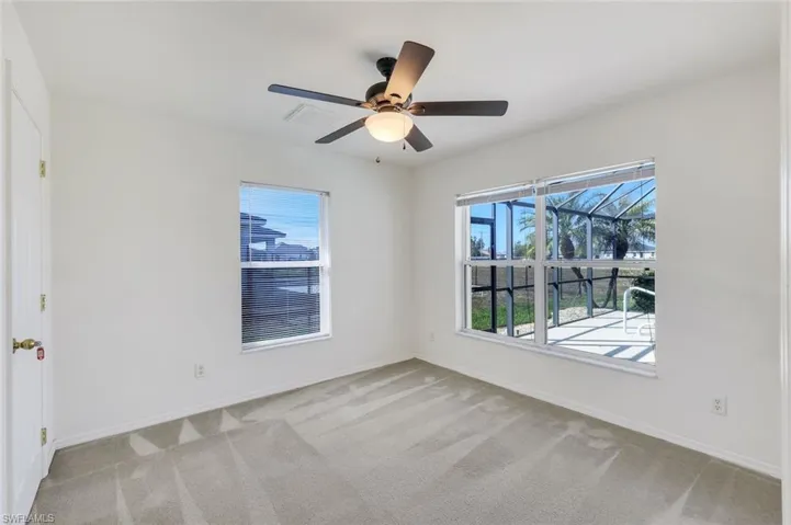 Spare room with ceiling fan and light colored carpet