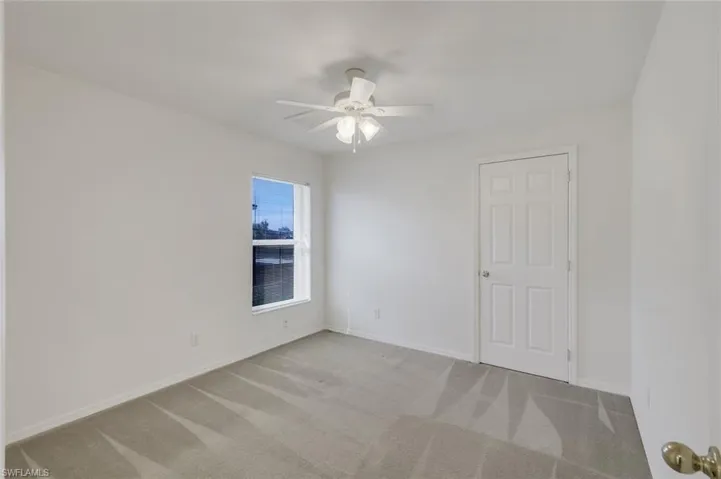 Unfurnished room with light carpet and a ceiling fan