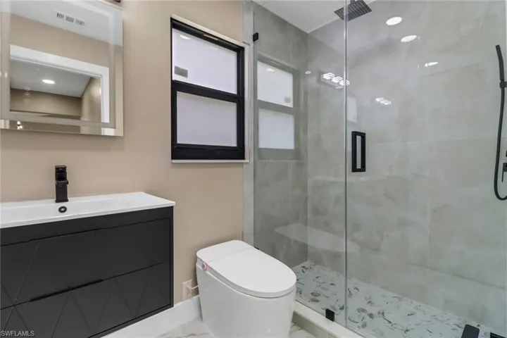Bathroom featuring a shower stall and vanity