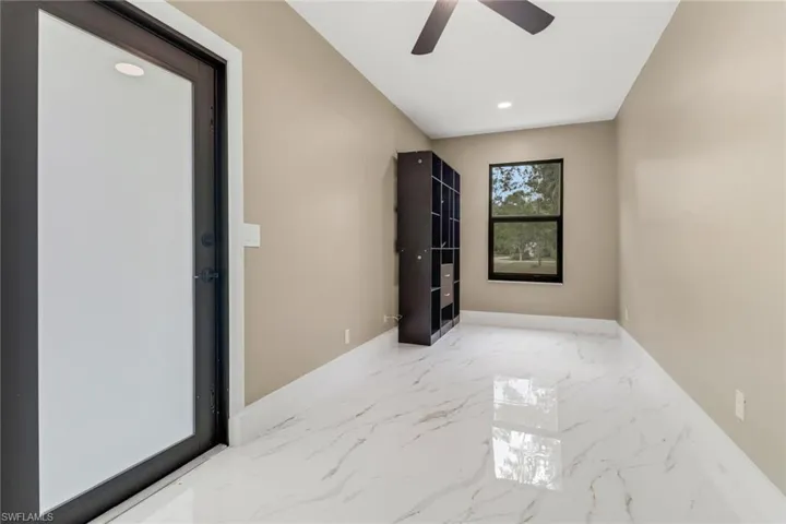Empty room featuring a ceiling fan, marble tiled floors, and recessed lighting