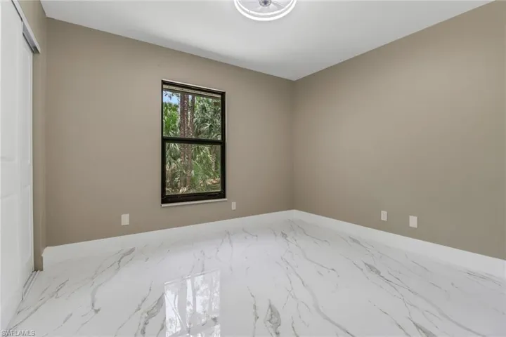 Spare room with marble finish flooring and baseboards