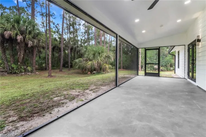 Unfurnished sunroom with a ceiling fan and vaulted ceiling