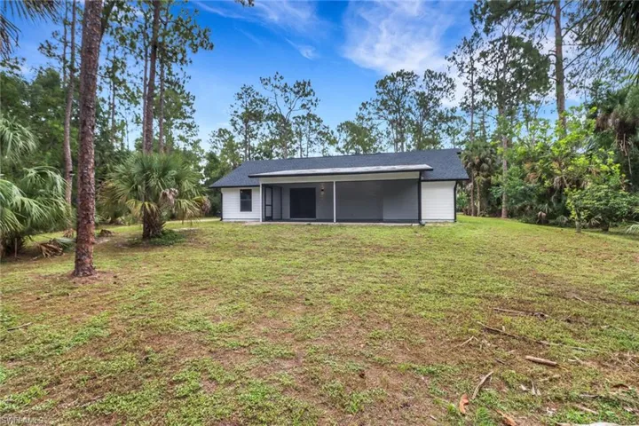 Rear view of house featuring a lawn