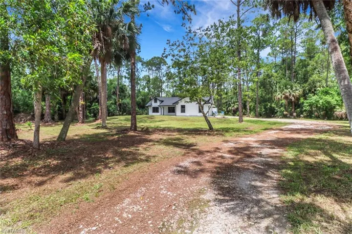 View of front facade with a front yard and driveway