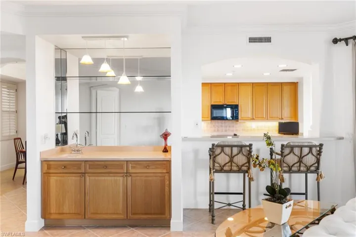Your wet bar has a sink and mirrored back and shelving.  Pass thru window makes it easy for entertaing!