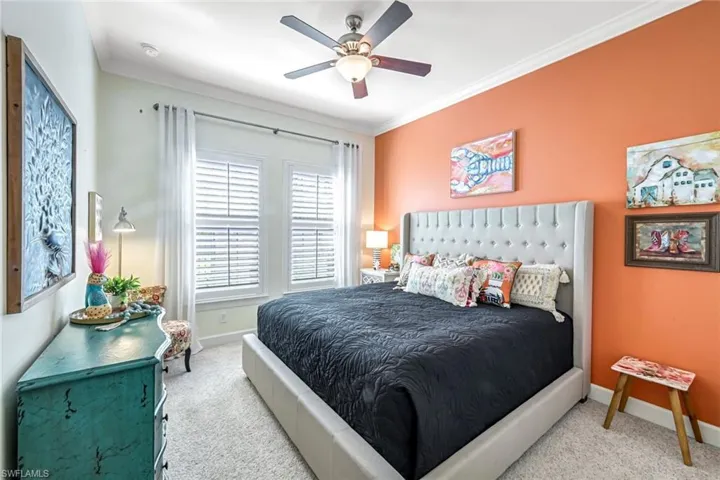 Bedroom with carpet, ornamental molding, and a ceiling fan