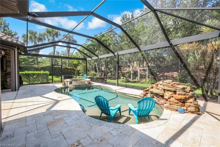 View of patio / terrace featuring a pool with connected hot tub and glass enclosure